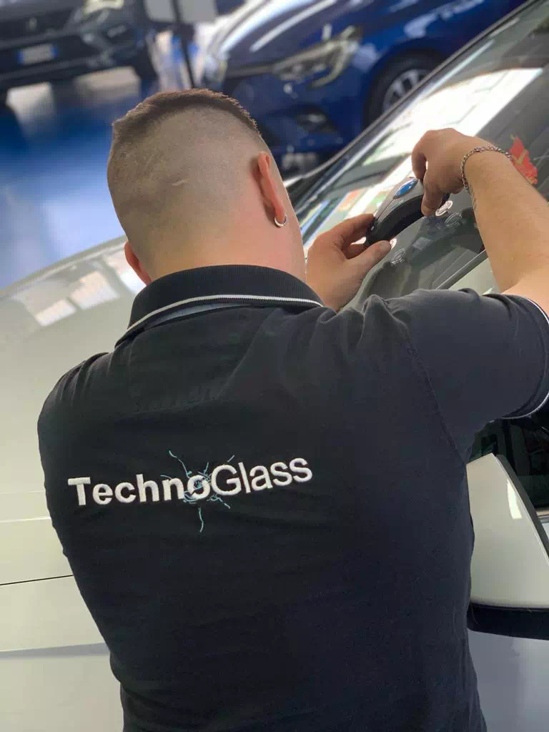 Operatore di spalle con una maglia Technoglass, azienda attiva a Varese e Novara, mentre lavora.