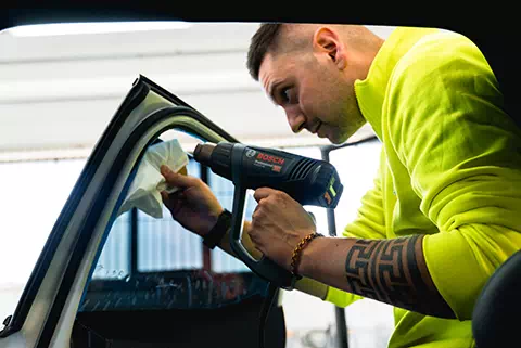 Operatore di Technoglass, attiva a Varese e Novara, sostituisce il finestrino laterale di un’auto.